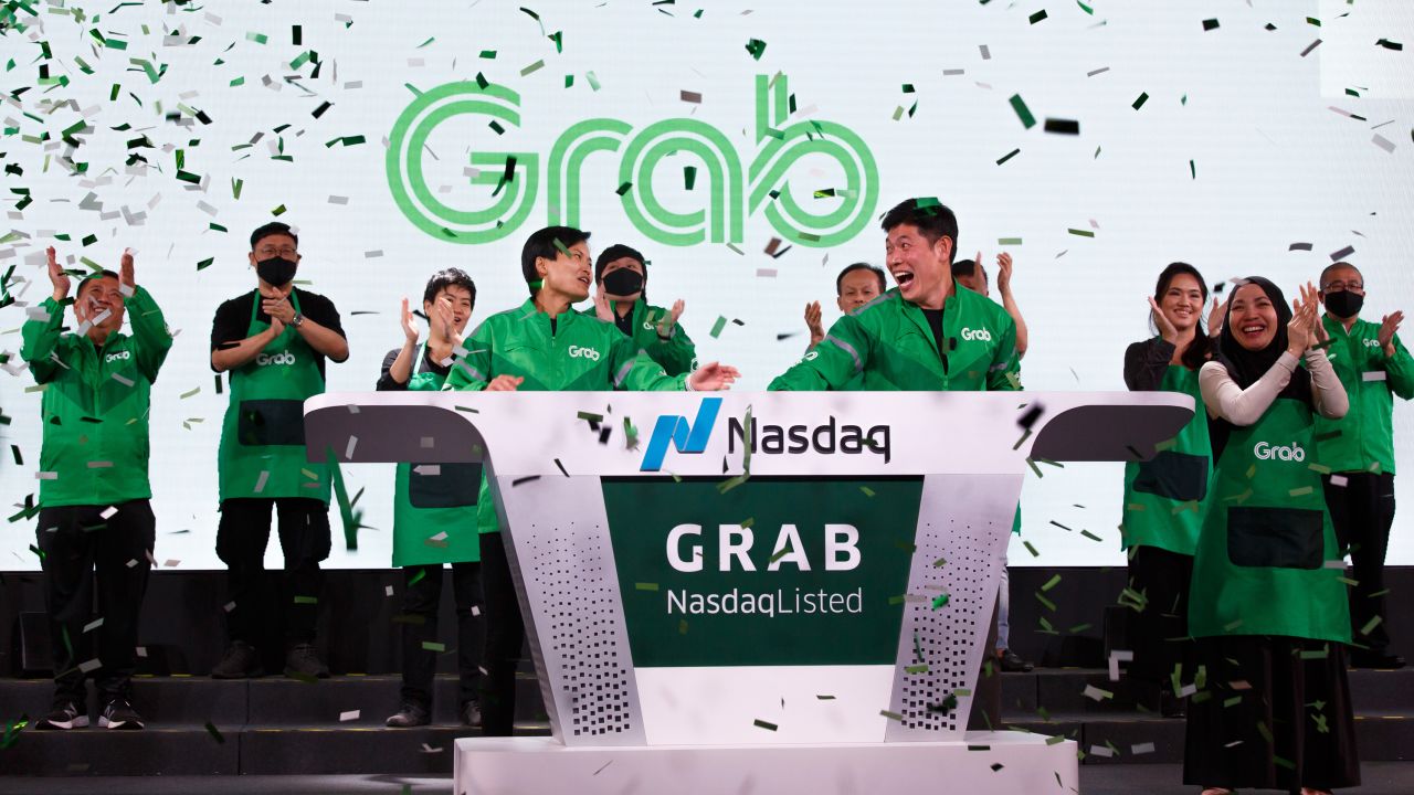 Grab's CEO, Anthony Tan, and co-founder Tan Hooi Ling, ring the bell as the Singapore-based company begins trading on the Nasdaq via a SPAC listing.