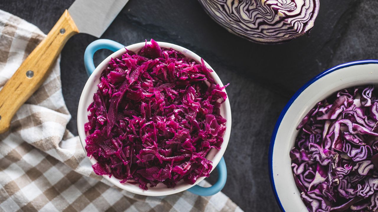 2E5K53T Red sauerkraut. Sour pickled cabbage in blue pot. Top view.