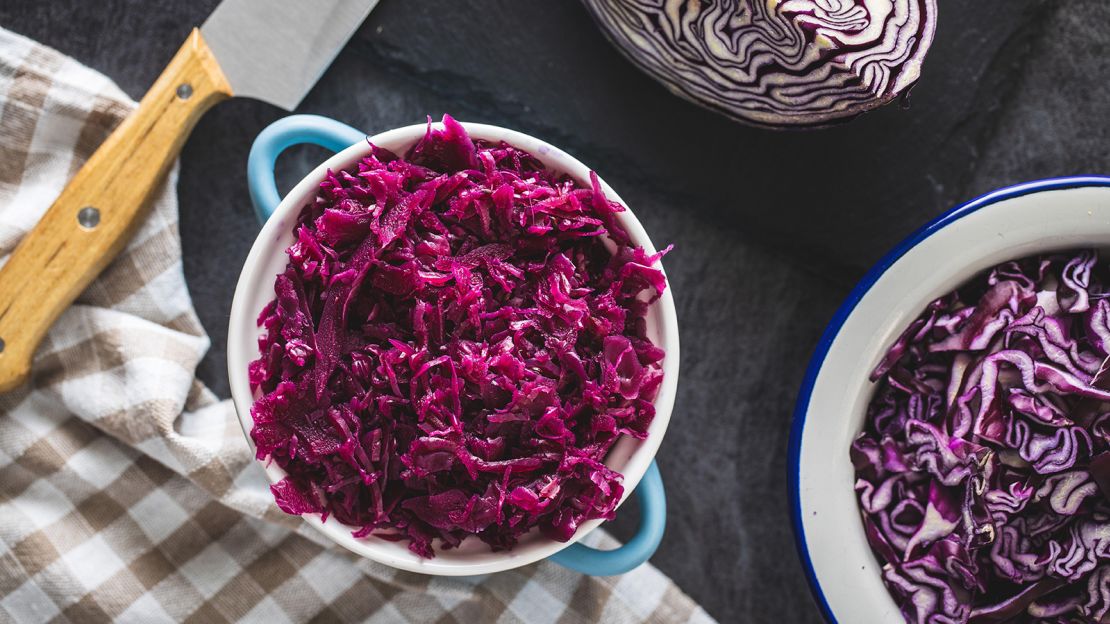 2E5K53T Red sauerkraut. Sour pickled cabbage in blue pot. Top view.