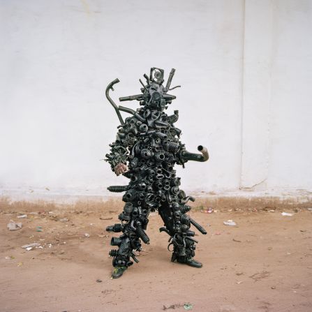 Hemock Kilomboshi poses in his costume made from recycled materials in Matonge district, Kinshasa. Kilomboshi performs in Kinshasa's streets to raise issues about globalization and economic plunder in the DRC.