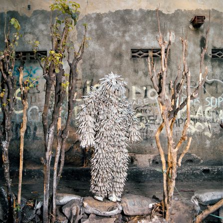 Another costume by Florian Sinanduku, photographed here in the Selembao distict, consists of numerous syringes. Sinanduku is a founding member of the Collectif Farata, a group of performance artists who perform in public locations in Kinshasa. 