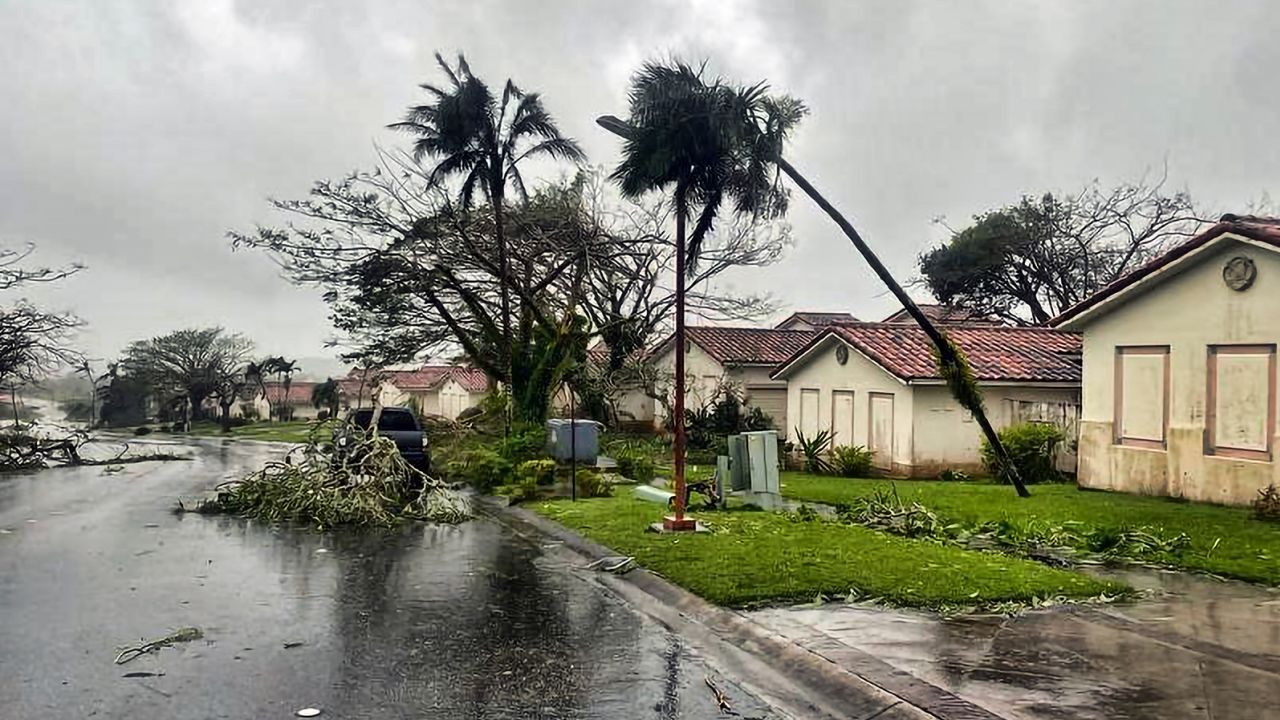 Downed tree branches litter a neighborhood in Yona, Guam, on Thursday.