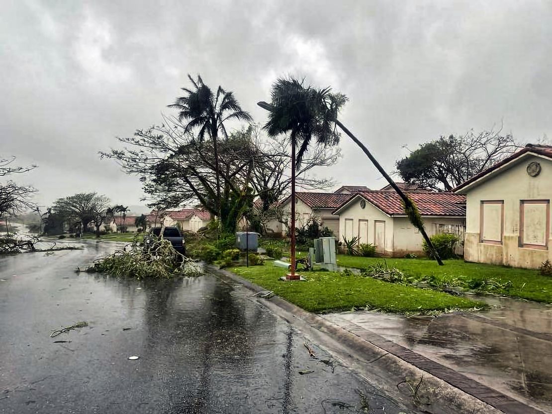 Downed tree branches litter a neighborhood in Yona, Guam, on Thursday.