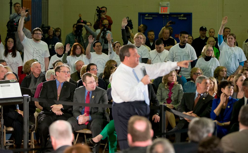 Demonstrators stand with the word "Bridgegate" spelled out on their shirts as Christie holds a town hall-style meeting in Flemington, New Jersey, in March 2014.