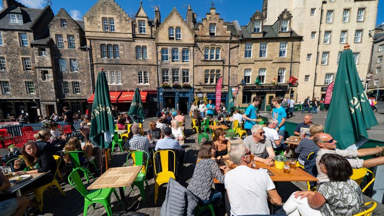 2JRAY5R Tourists eating in outdoor restaurant in The Grassmarket in Edinburgh Old Town, Scotland, Uk