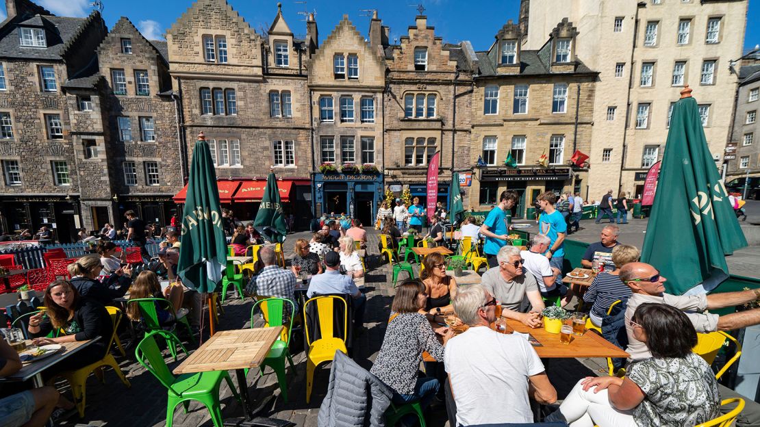 2JRAY5R Tourists eating in outdoor restaurant in The Grassmarket in Edinburgh Old Town, Scotland, Uk