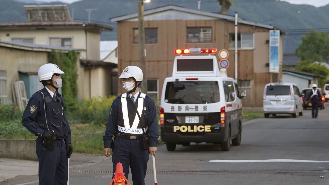 Police officers stand near the scene of the attack. Gun violence in Japan is extremely rare. 