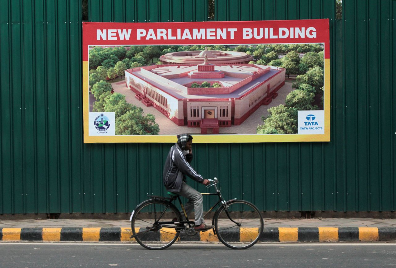 A cyclist rides past the construction site for the new Parliament building, part of the Central Vista Project redevelopment project, on January 8, 2021 in New Delhi.