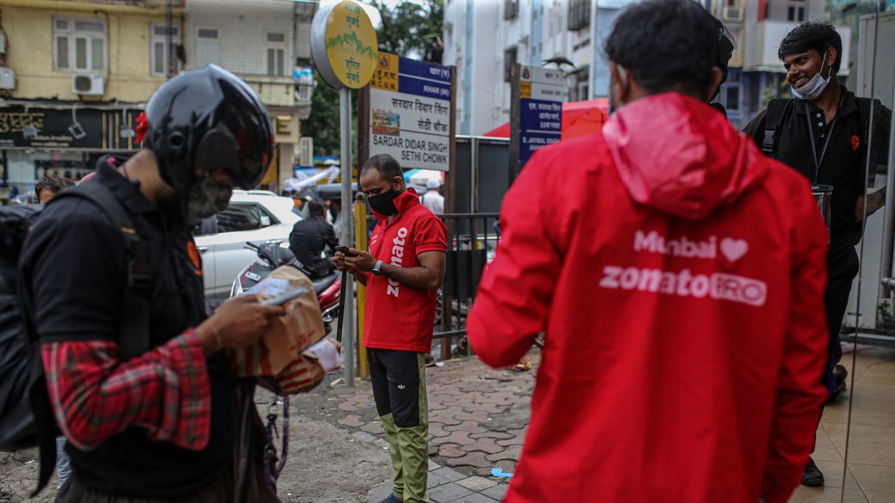 Delivery riders for Zomato Ltd., center, and Swiggy, operated by Bundl Technologies Pvt., wait to collect orders from a restaurant in Mumbai, India, on Friday, July 16, 2021. Zomato $1.3 billion initial public offering was fully subscribed on the first day of sale, after anchor funds including BlackRock Inc. bid for 35 times more stock than was offered to them. Photographer: Dhiraj Singh/Bloomberg via Getty Images