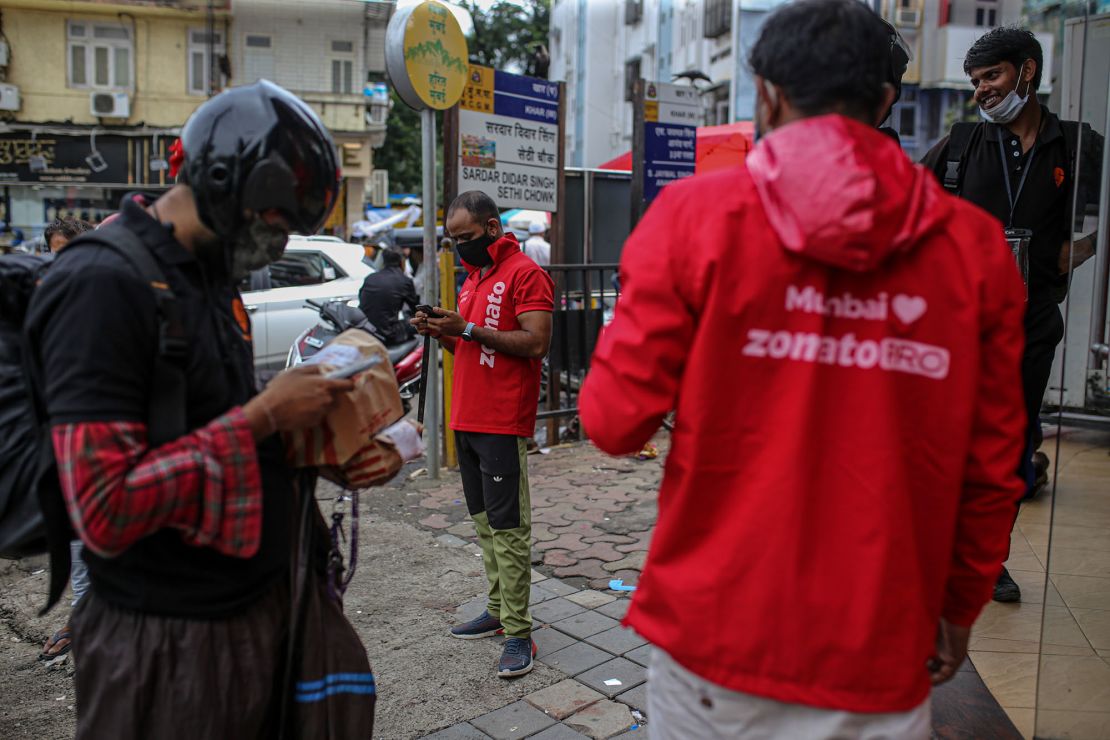 Delivery riders for Zomato Ltd., center, and Swiggy, operated by Bundl Technologies Pvt., wait to collect orders from a restaurant in Mumbai, India, on Friday, July 16, 2021. Zomato $1.3 billion initial public offering was fully subscribed on the first day of sale, after anchor funds including BlackRock Inc. bid for 35 times more stock than was offered to them. Photographer: Dhiraj Singh/Bloomberg via Getty Images