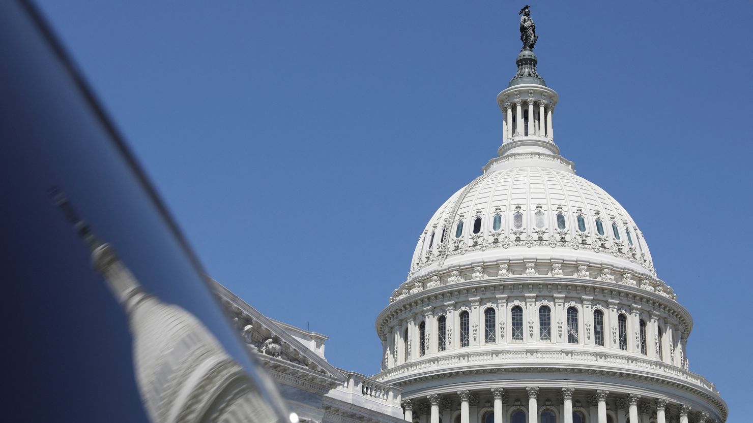The dome of the US Capitol is reflected in a window on Capitol Hill in Washington on April 20, 2023.