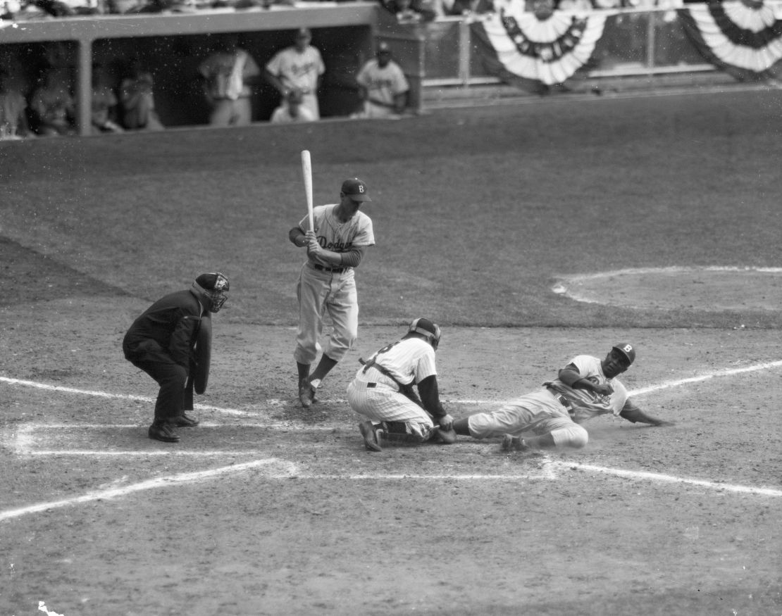 In a file photo -- September 28, 1955 -- Jackie Robinson (R) is safe under an attempted out by Yankee catcher Yogi Berra, on a steal home from third. Pinch hitter Frank Kellert (L) waits to bat. The Yankees beat the Dodgers 6-5.
