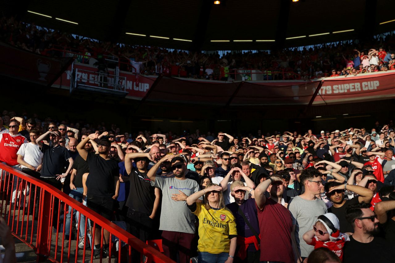 Arsenal fans shield their eyes from the sun as they watch their football club play Nottingham Forest in a Premier League match in Nottingham, England, on Saturday, May 20.