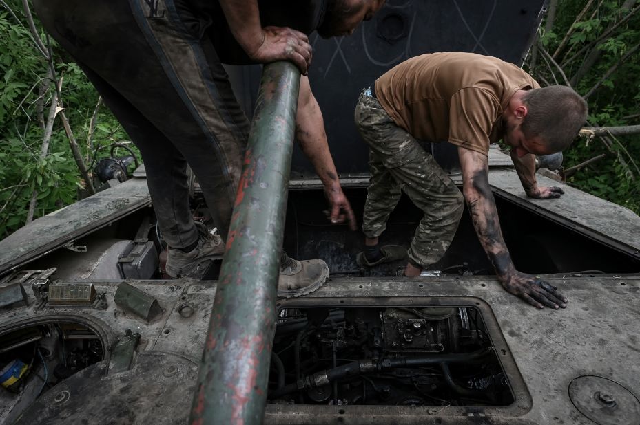 Two Ukrainian servicemen repair an engine on an infantry fighting vehicle in the country's Donetsk region on Monday, May 22.