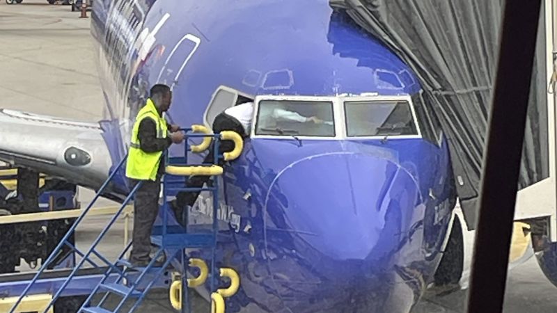 A Southwest pilot crawls through the cockpit window after the flight deck door is locked