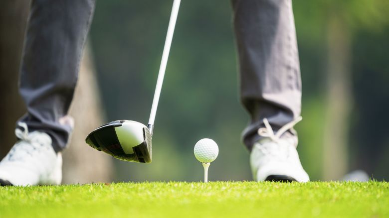 Golfer play golf in the golf field during sunset.Playing golf. Golf club and ball. Preparing to shot.