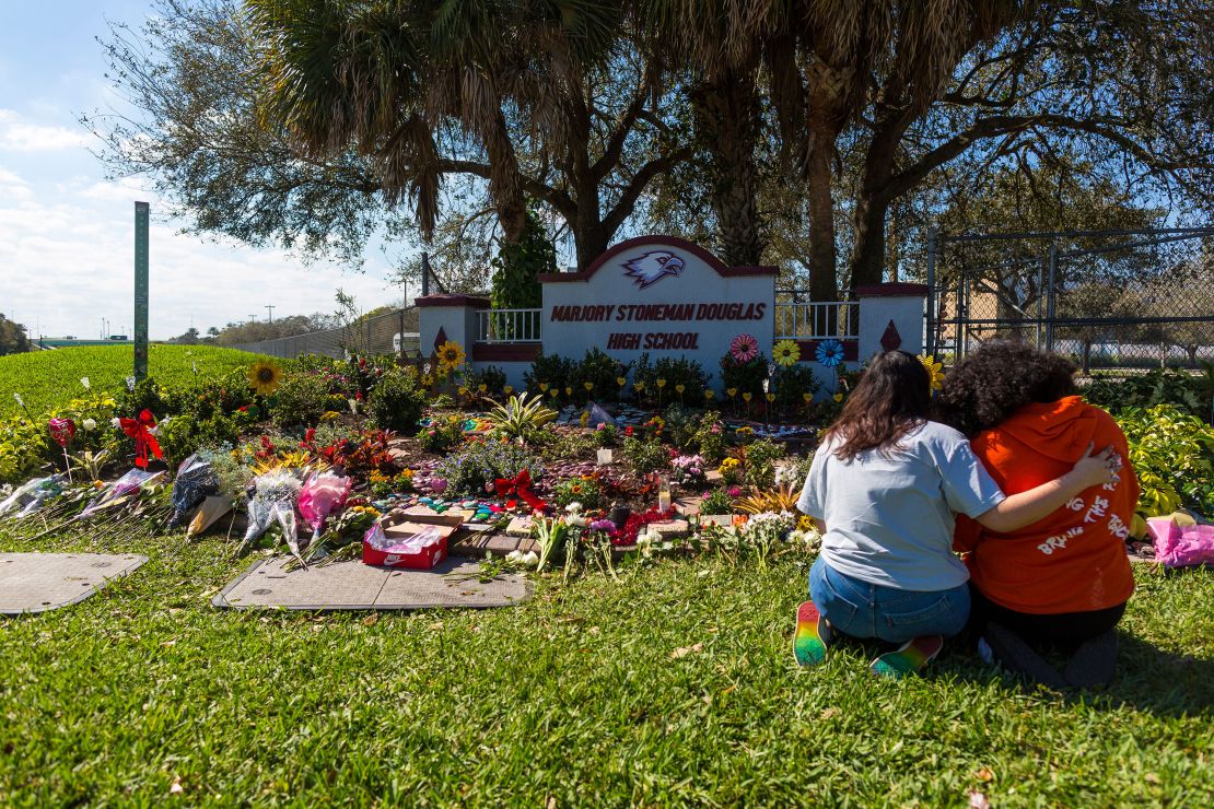 Two people embrace on February 14 -- the fifth anniversary of the mass shooting -- at a memorial at Marjory Stoneman Douglas High School in Parkland, Florida. 