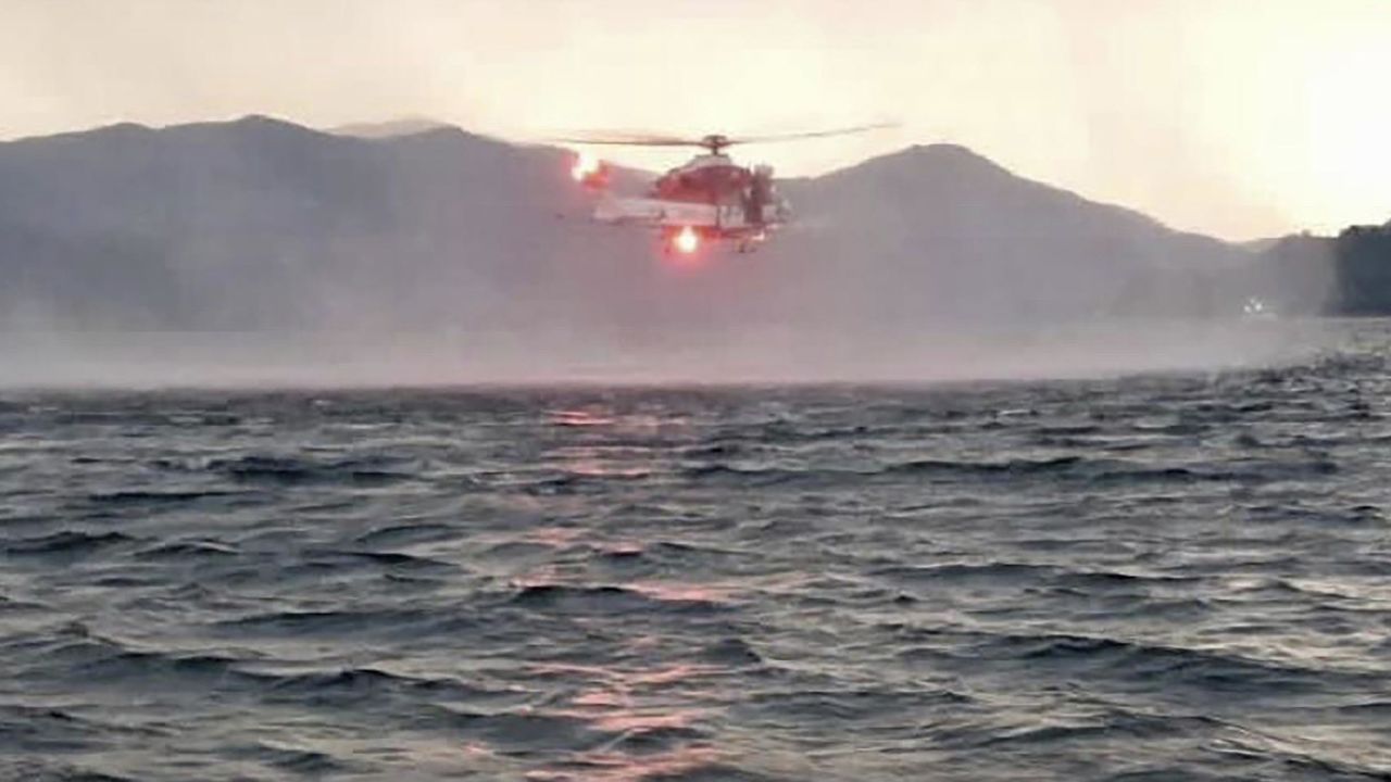 A helicopter searches for missing passengers after a tourist boat capsized in a storm on Lake Maggiore, Italy, on Sunday.