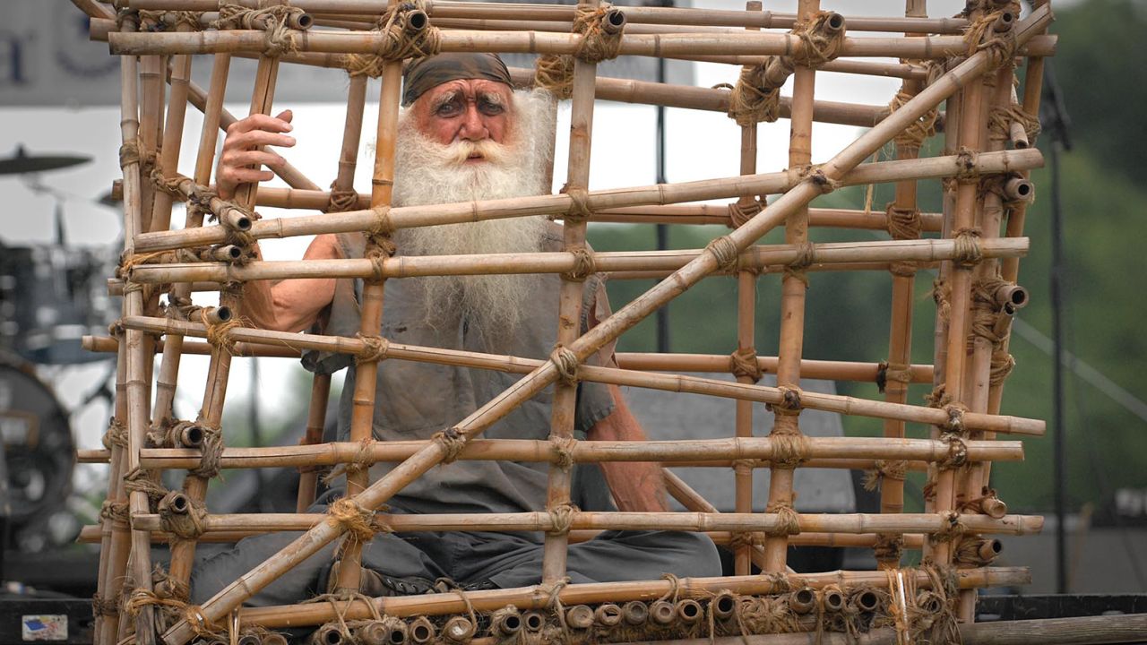 A man portrays a prisoner of war in a Vietnam-era 