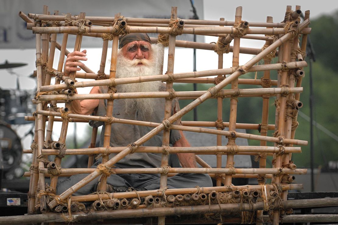 A man portrays a prisoner of war in a Vietnam-era "tiger cage" at a veterans event in Washington in 2011.