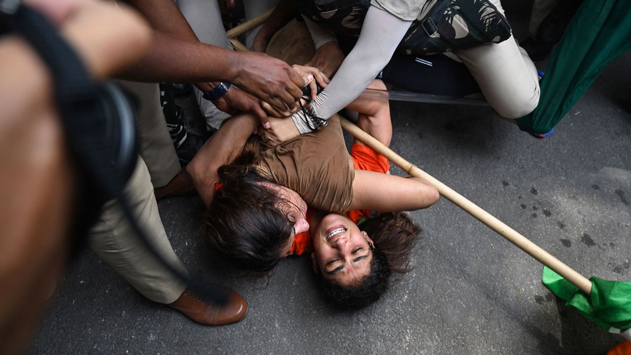 Indian wrestlers Sangeeta Phogat and Vinesh Phogat struggle as they are detained by the police while attempting to march to India's new parliament in New Delhi on May 28, 2023.