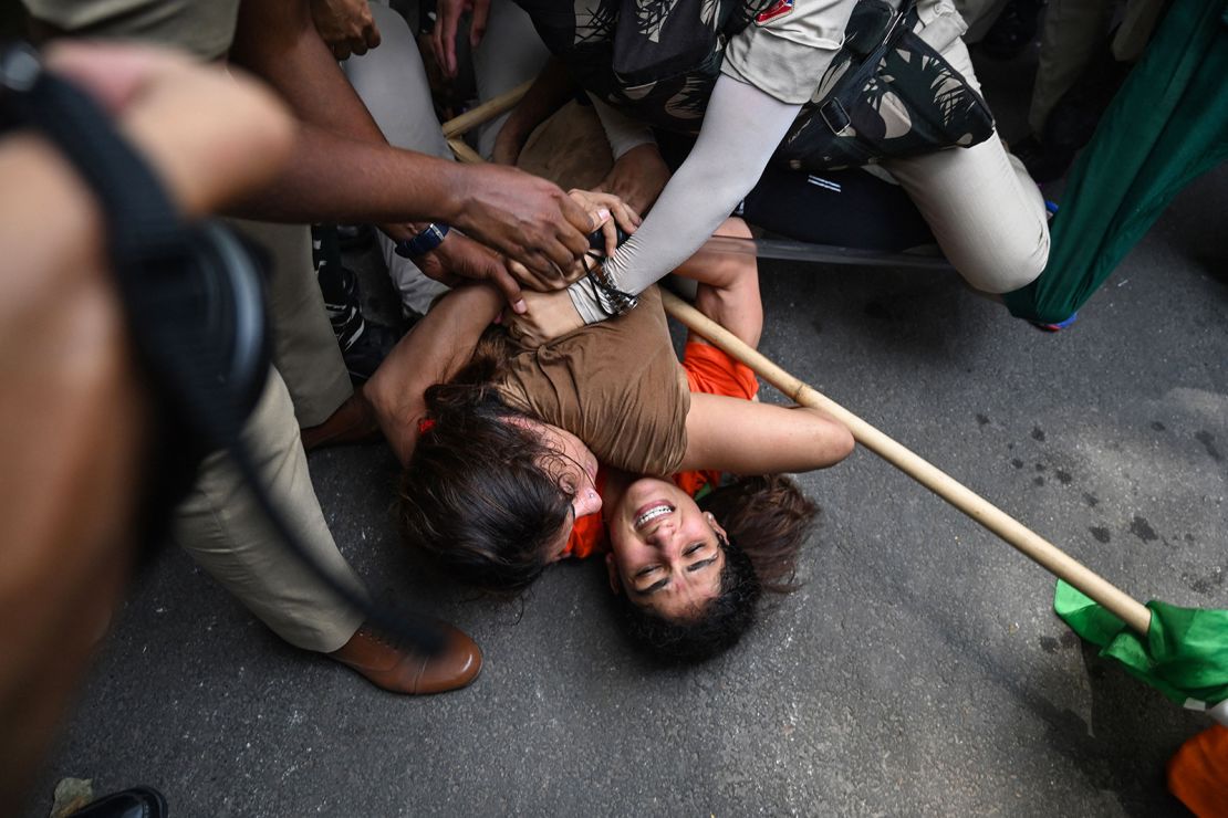 Indian wrestlers Sangeeta Phogat and Vinesh Phogat struggle as they are detained by the police while attempting to march to India's new parliament in New Delhi on May 28, 2023.