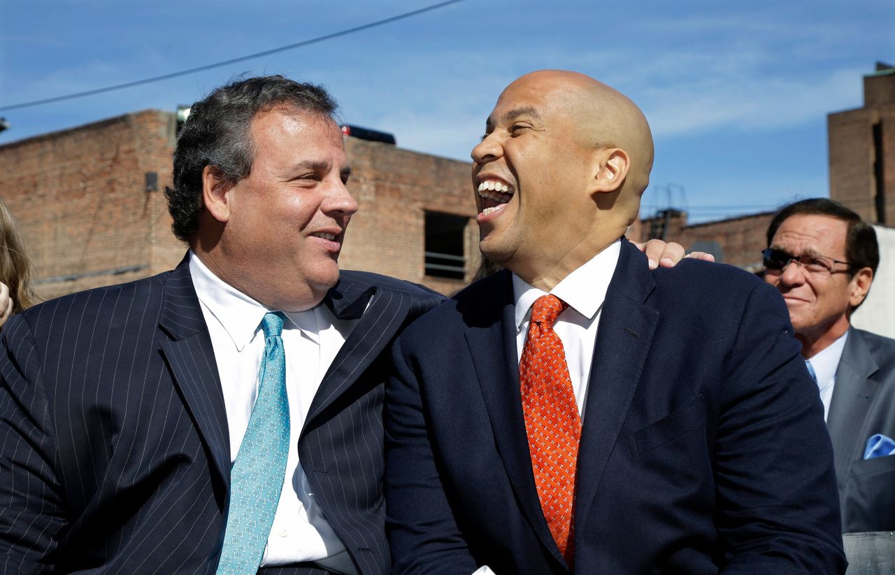 Christie and Newark Mayor Cory Booker share a laugh during a ribbon-cutting ceremony for Newark charter schools in September 2013.
