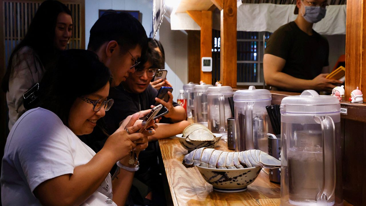 Digell Huang, 34 tuổi, một trong hai khách hàng đặt trước chụp ảnh món ramen isopod khổng lồ ở Đài Bắc, Đài Loan ngày 27 tháng 5 năm 2023. REUTERS/Ann Wang