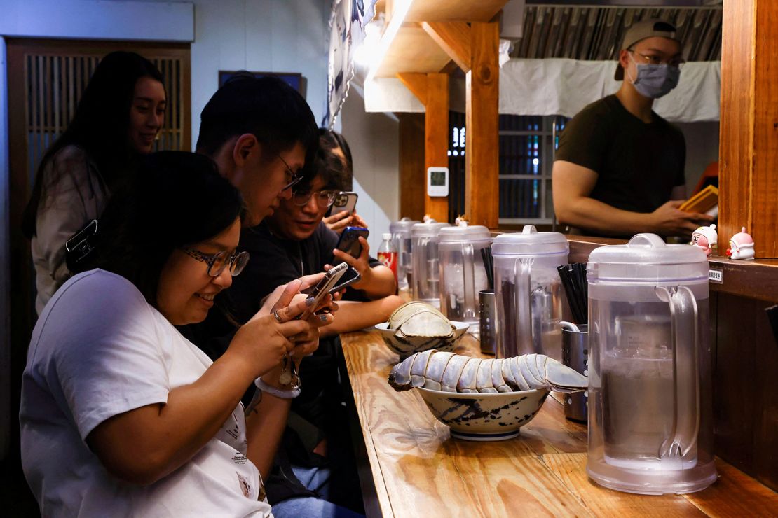 Digell Huang, 34, one of the two reserved customers takes photos of the giant isopod ramen in Taipei, Taiwan May 27, 2023. REUTERS/Ann Wang