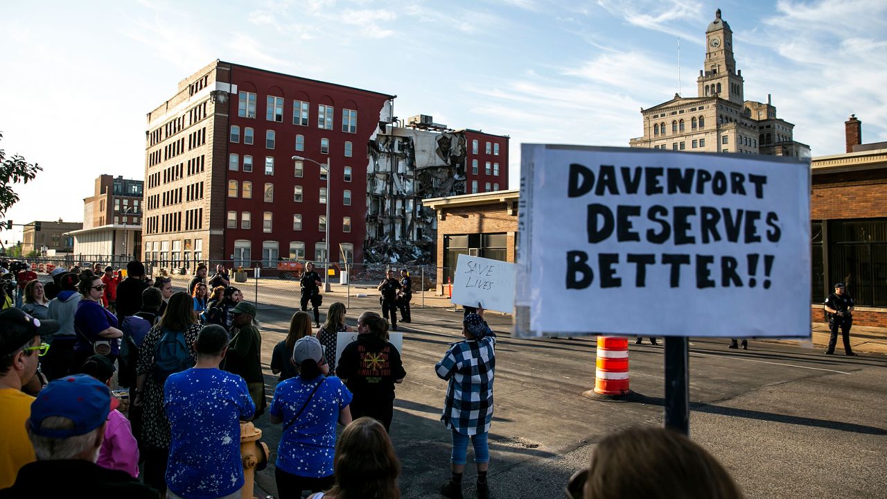 Demonstrators rally Tuesday in support of continuing search efforts at a partially collapsed apartment building.