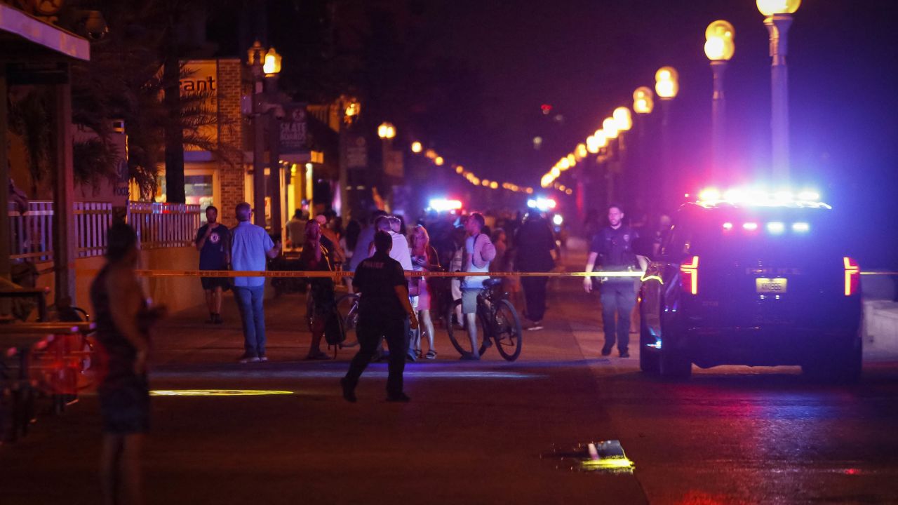 Bystanders and Hollywood Police officers are seen nearby the shooting scene in Hollywood, Florida, Monday night.
