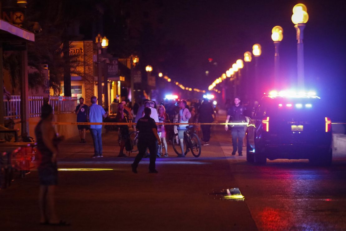Bystanders and Hollywood Police officers are seen nearby the shooting scene in Hollywood, Florida, Monday night.