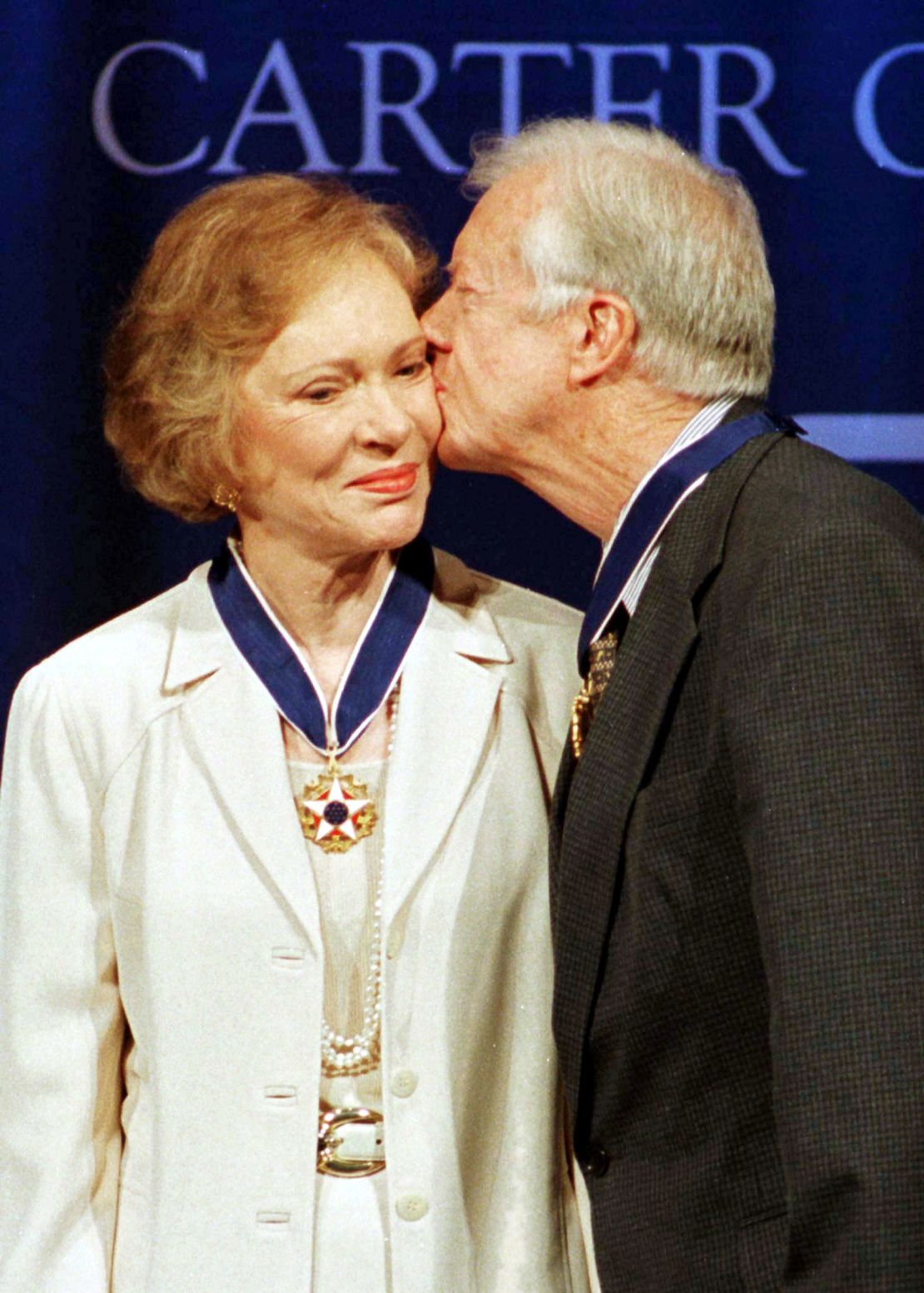 Former President Jimmy Carter (R) kisses former first lady Rosalynn Carter on the cheek after they received the Presidential Medal of Freedom, the nations' highest honor, from President Bill Clinton during a ceremony at the Carter Center in Atlanta, August 9. The Carters were presented with the medals for the work they have done since leaving the White House in 1980.