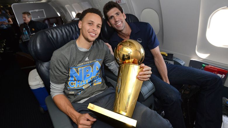 OAKLAND, CA - JUNE 17:  Stephen Curry #30 and Bob Myers of the Golden State Warriors holds the NBA trophy on the plane as the team travels home from Cleveland after winning the 2015 NBA Finals on June 17, 2015 in Oakland, California. NOTE TO USER: User expressly acknowledges and agrees that, by downloading and/or using this Photograph, user is consenting to the terms and conditions of the Getty Images License Agreement. Mandatory Copyright Notice: Copyright 2015 NBAE (Photo by Noah Graham/NBAE via Getty Images)