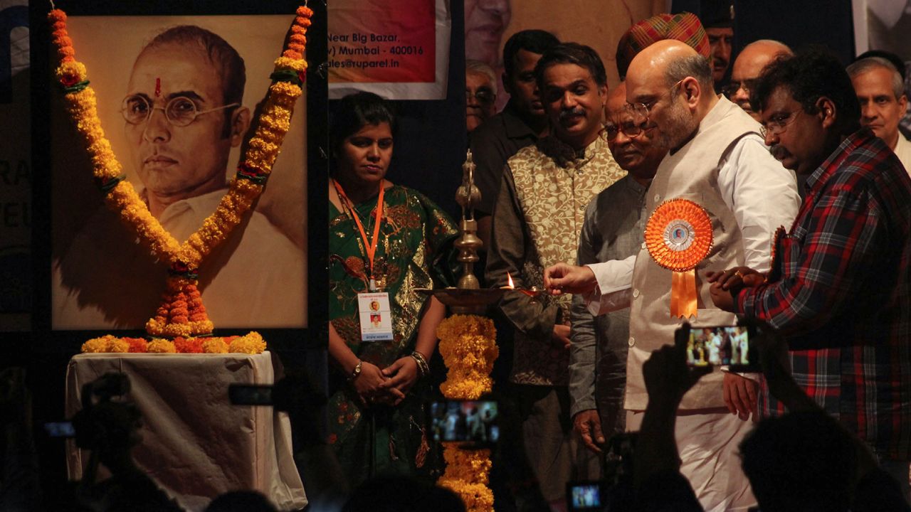 Indian home minister Amit Shah pictured alongside a garlanded photo of Savarkar on April 21, 2017 in Mumbai, India. 