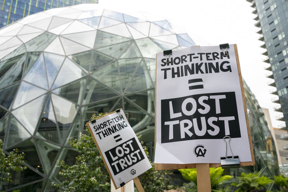 Amazon workers hold signs during a walkout event at the company's headquarters on May 31, 2023 in Seattle, Washington. The protest action was organized to call attention to return to office requirements, in addition to recent layoffs and climate change issues. 
