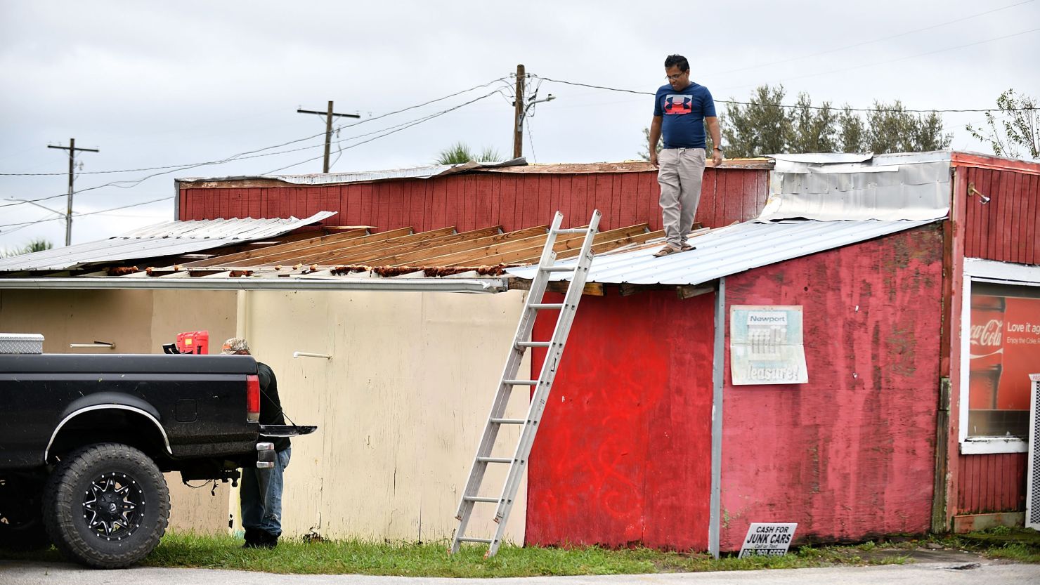 Talukder Mahtab surveys the roof of his business after it was hit by the winds and rain from Hurricane Ian on September 29, 2022 in Bartow, Florida.