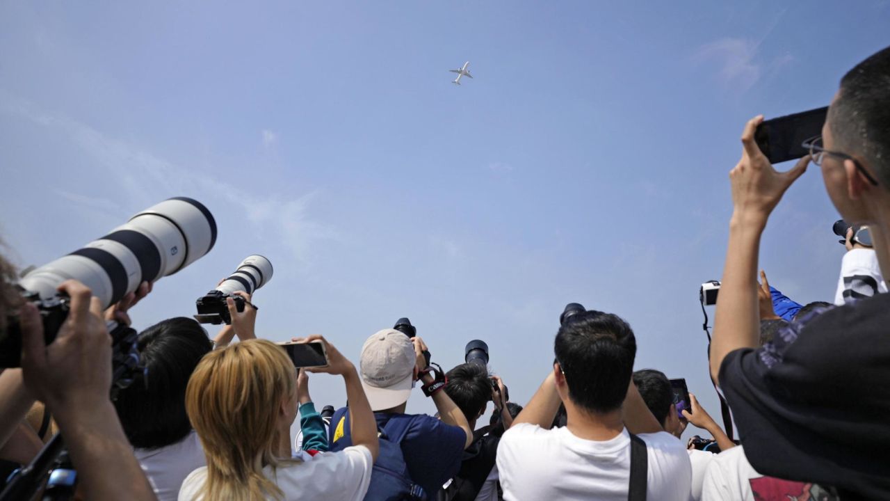 People taking photos of China's C919 passenger jet, on its maiden commercial flight, at a park near Beijing Capital International Airport on Sunday.
