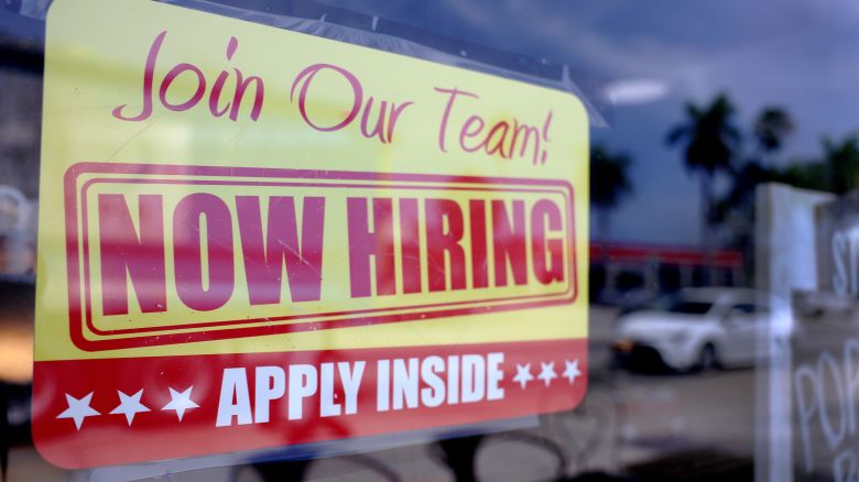 A 'Now Hiring' sign posted in the window of a restaurant looking to hire workers on May 05, 2023 in Miami, Florida. 