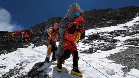 Ngima Tashi Sherpa walks as he carries a Malaysian climber while rescuing him from the death zone above camp four at Everest, Nepal, May 18, 2023 in this screengrab obtained from a handout video.