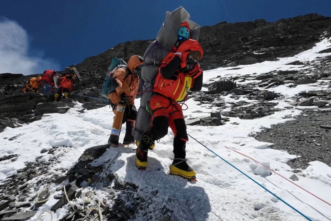 Ngima Tashi Sherpa walks as he carries a Malaysian climber while rescuing him from the death zone above camp four at Everest, Nepal, May 18, 2023 in this screengrab obtained from a handout video.