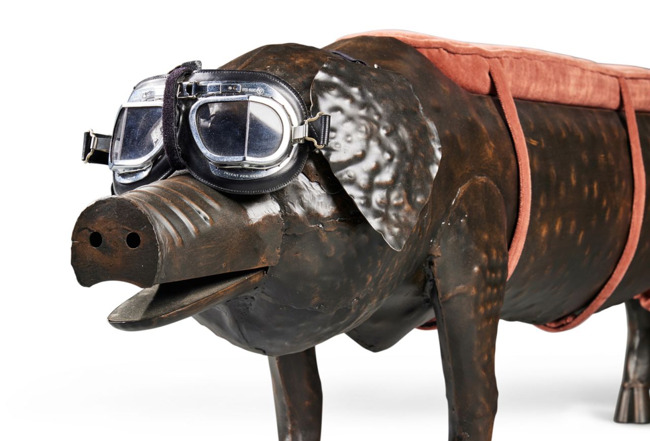 The tin pig bench is wearing aviator goggles.