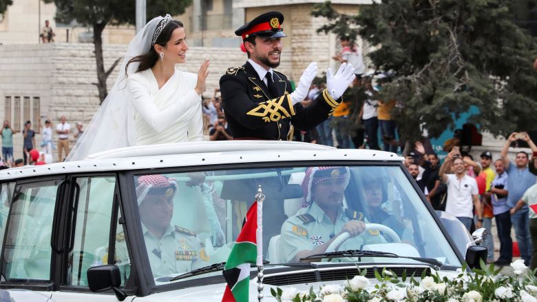 Jordan's Crown Prince Hussein and Rajwa Alseif wave to crowds on their wedding day in Amman.