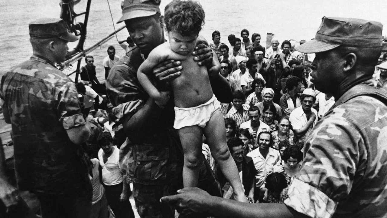 A US Marine helps a young Cuban child off a boat arriving in Key West, Florida, on May 10, 1980. 