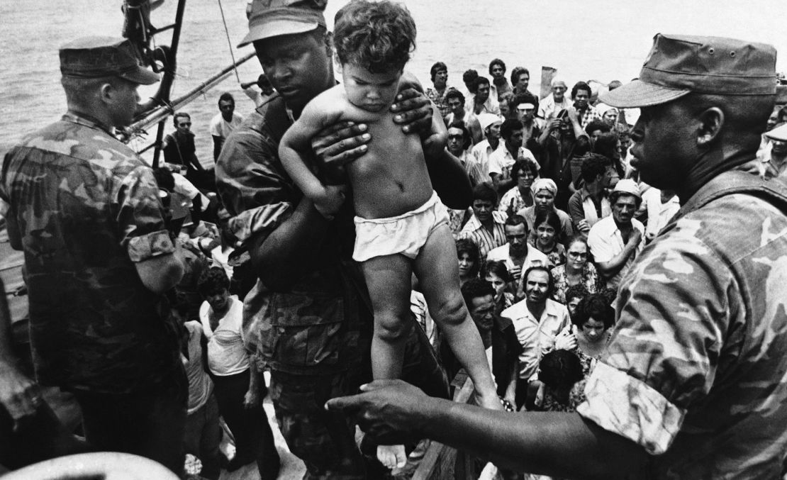 A US Marine helps a young Cuban child off a boat arriving in Key West, Florida, on May 10, 1980. 
