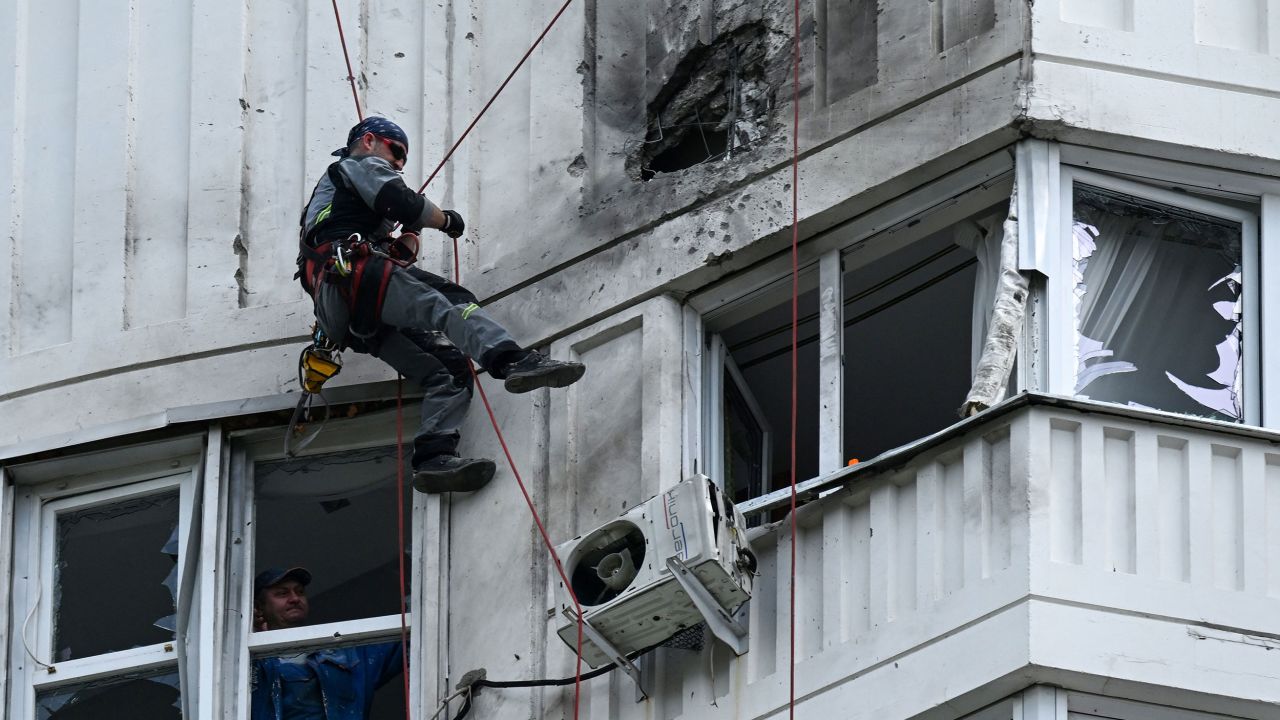 A specialist inspects the damaged facade of an apartment building after a reported drone attack in Moscow on May 30, 2023.