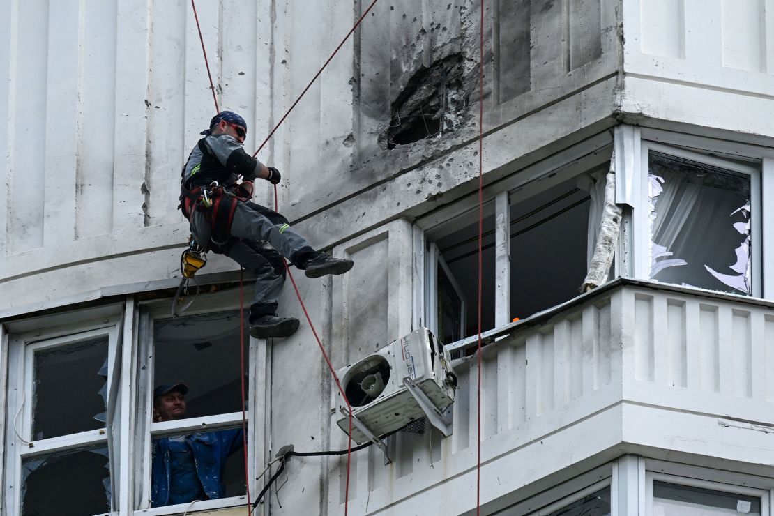 A specialist inspects the damaged facade of an apartment building after a reported drone attack in Moscow on May 30, 2023. 