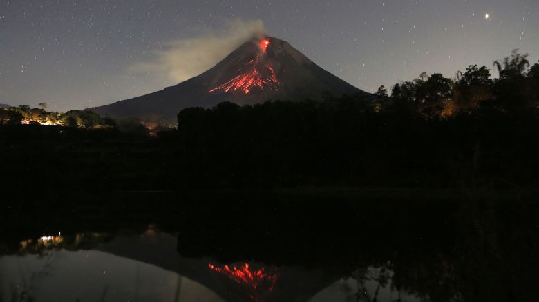TOPSHOT - A long exposure photo shows Mount Merapi volcano releasing hot lava with its reflection seen on the Kendil lake at the Srumbung village in Magelang, Central Java on May 28, 2023. (Photo by DEVI RAHMAN / AFP) (Photo by DEVI RAHMAN/AFP via Getty Images)