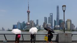 SHANGHAI, CHINA - MAY 29: Tourists holding umbrellas visit the Bund with skyscrapers in the background during heat waves on May 29, 2023 in Shanghai, China. (Photo by Wang Gang/VCG via Getty Images)