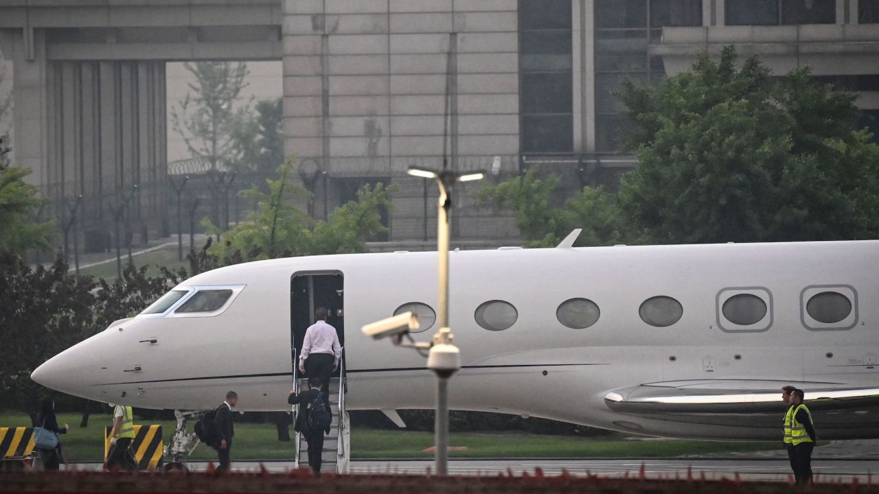 Elon Musk (in white) boards his private jet before departing from Beijing Capital International Airport on May 31, 2023. He was traveling to Shanghai.